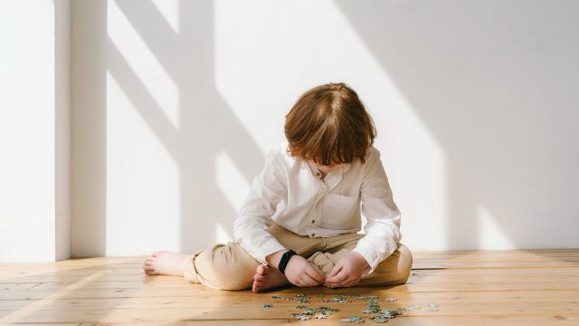 Boy in White Long Sleeve Shirt Playing Puzzle